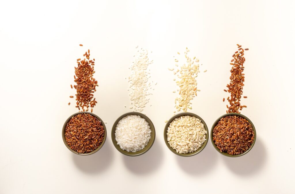 Raw rice assortment in bowl on white background. Horizontal. Place for text. Top view.